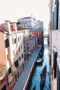a group of boats in a canal between buildings at Residenza Dei Dogi in Venice