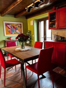 a kitchen with a wooden table and red chairs at Maison Ama Charvensod in Charvensod +8 photos