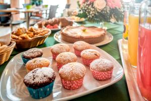 a tray with cupcakes and a cake on a table at Agriturismo B&B Il Girasole in Oriago Di Mira