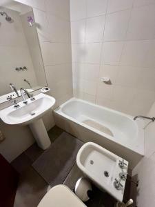 een badkamer met een wastafel, een toilet en een bad bij Departamento M&L in San Martín de los Andes +6 foto's