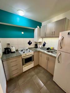 een kleine keuken met een fornuis en een koelkast bij Departamento M&L in San Martín de los Andes