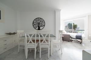 a white dining room with a table and chairs at Frente al Mar y Paseo marítimo en el centro Marbella in Marbella