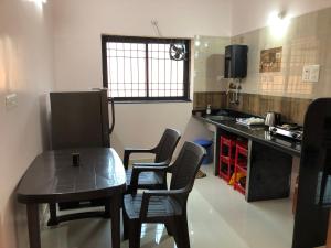 a small kitchen with a table and chairs in a room at Mahalaxmi Homestay II in Mapusa +6 photos