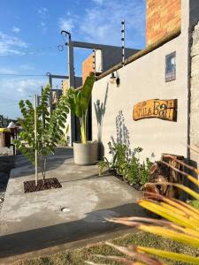a sidewalk with plants and a sign on a building at Casa Villa Bali in Marechal Deodoro