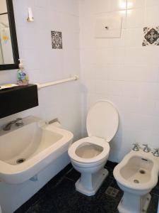 ein weißes Badezimmer mit Toilette und Waschbecken in der Unterkunft Monoambiente Falucho al 1500 - Centro - in Mar del Plata + 10 Fotos