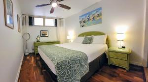 a bedroom with a bed and a ceiling fan at Check In, Chill Out - Annies Surf Shack Awaits! in Kahana