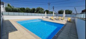 a swimming pool with chairs and umbrellas on a house at JP VILLAGE Hotel in Nelas