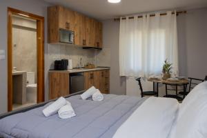 a bedroom with a large bed with towels on it at Astria Apartment 2 in Kalabaka