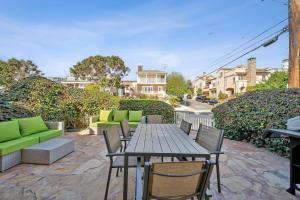 a patio with a wooden table and chairs at Coastal Pet Friendly Gem Near the Beach and Shopping in Newport Beach