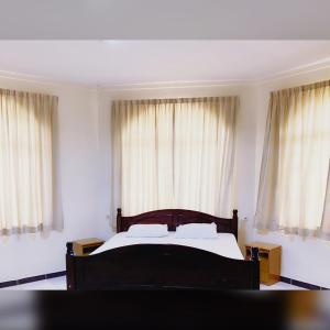 a bedroom with a bed and two large windows at Paramaribo Villa 8p Full Airco Near Mall in Paramaribo