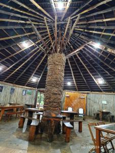 玛丽亚达费Pousada Shambhala的一个摆放着木桌、天花板很高的房间。 更多51张照片