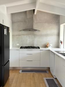 a kitchen with white cabinets and a stove top oven at Oceanview Sunset Villa Hallett Cove 3BR 2Bath Large Deck Free Parking in Halletts Cove