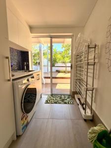 a kitchen with a washer and a door to a patio at Oceanview Sunset Villa Hallett Cove 3BR 2Bath Large Deck Free Parking in Halletts Cove