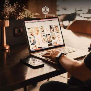 a person sitting at a table using a laptop computer at Prishtina Host in Prishtinë