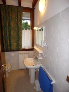 a bathroom with a sink and a toilet and a mirror at Hotel Residence Margherita in Montecreto