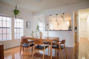 Un comedor con mesa y sillas de madera. en Cozy Bohemian Bungalow, en Houston