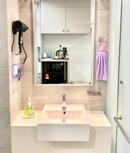 Un baño con un lavabo blanco y un espejo. en KL Sentral Monorail 4 pax Family KL City View Infinity Sky Pool, en Kuala Lumpur 31 fotos más