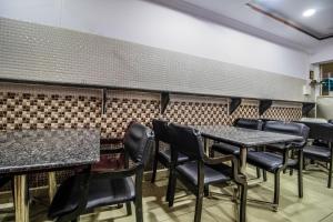 SecunderābādHotel O Grand Brundavan的用餐室配有黑色的椅子和桌子