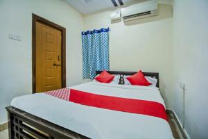 SecunderābādHotel O Grand Brundavan的卧室里有一张大床，配有红色枕头