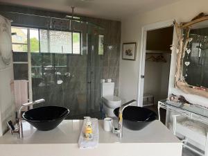 un bagno con due lavandini e una doccia di Gina‘s Place a Peregian Beach Altre 7 foto