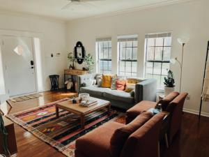 una sala de estar con un sofá y una mesa en Cozy Bohemian Bungalow, en Houston