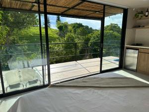 a bedroom with a bed and a balcony with a view at Cielo Abierto Cabaña Glamping in Quimbaya