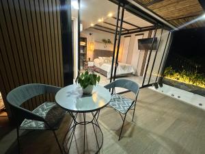 a table and chairs on a balcony with a bedroom at Cielo Abierto Cabaña Glamping in Quimbaya