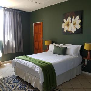 a bedroom with a large bed with a green wall at Me Time in Johannesburg