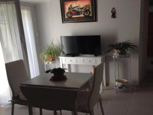 a dining room with a table and a tv at Charming town centre house with garden in Dax