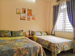 a bedroom with two beds and a window at Ola's Home in Ho Chi Minh City
