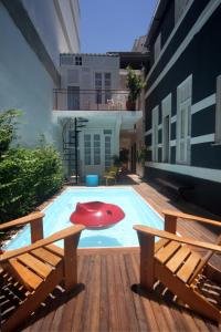 a patio area with chairs, tables, and benches at Casa Tuxi in Rio de Janeiro