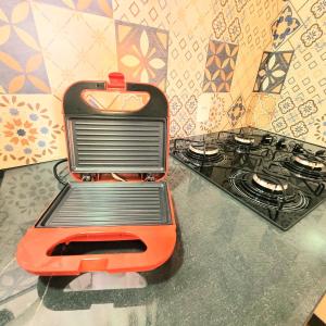 a toaster oven sitting on a counter next to a stove at Perfeito Studio 21 in Poços de Caldas +12 photos