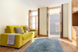 a living room filled with furniture and a window at Chateau Apartments in Porto