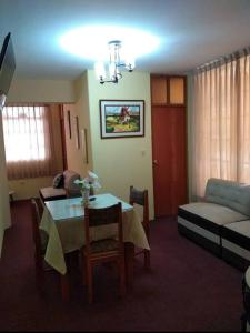 a living room with a table and a couch at Departamento ORILLAS DEL LAGO in Puno