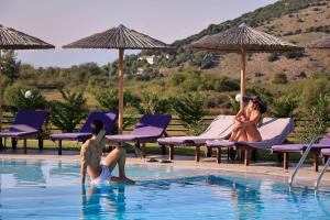 two people playing in the swimming pool at a resort at Aar Hotel & Spa Ioannina in Ioannina