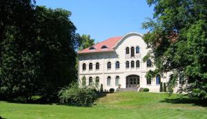 ein großes weißes Gebäude mit rotem Dach in der Unterkunft Schlosshotel Marihn in Marihn