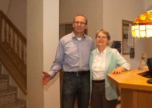 a man and a woman standing next to a table at Hotel Arcus in Elsterwerda