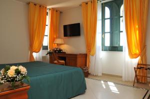 a bedroom with a bed and a window with orange curtains at Villa Irlanda Grand Hotel in Gaeta