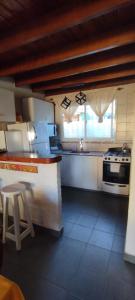 a kitchen with a stove and a counter with a stool at Casa verde Alfar in Mar del Plata