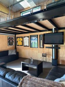 a living room with a couch and a tv at Mount Jowett Retreat in Whanganui