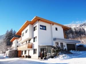 ein großes weißes Gebäude im Schnee in der Unterkunft Apart Zillertal in Aschau