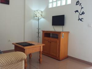 a living room with a tv and a table and a lamp at BBQ Evita Beach Club in Benalmádena