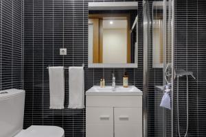uma casa de banho com um WC, um lavatório e um espelho. em Chateau Apartments no Porto
