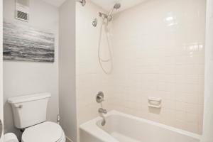 a white bathroom with a toilet and a shower at Land's End 5-204 Gulf-Bay Front - Premier in St. Pete Beach