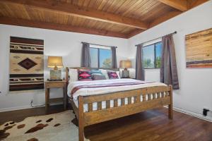a bedroom with a large bed and two windows at Taos Pine Home in Taos