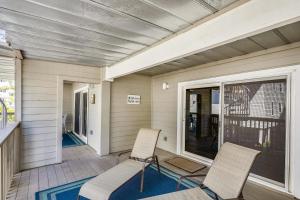 a porch with two chairs and a window at Pelican Pointe 2C in Clearwater Beach