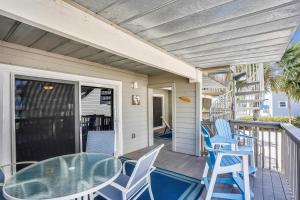 a patio with blue chairs and a glass table on a porch at Pelican Pointe 2C in Clearwater Beach