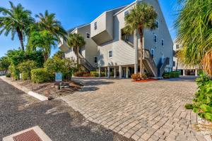 a brick driveway in front of a building with palm trees at Pelican Pointe 2C in Clearwater Beach