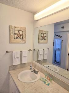 a bathroom with a sink and a large mirror at Oceanview Studio Condo w Balcony - Castaways Beach Resort in Daytona Beach