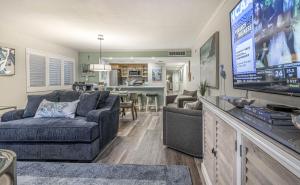 a living room with a couch and a flat screen tv at Land's End 4-306 Bay Front - Premier in St Pete Beach